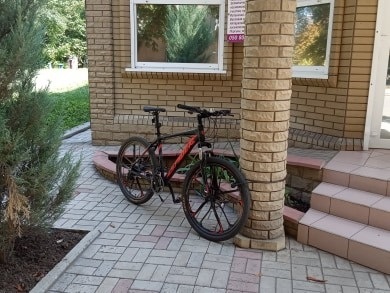 Велосипед, прикручений до стовпа біля салону краси